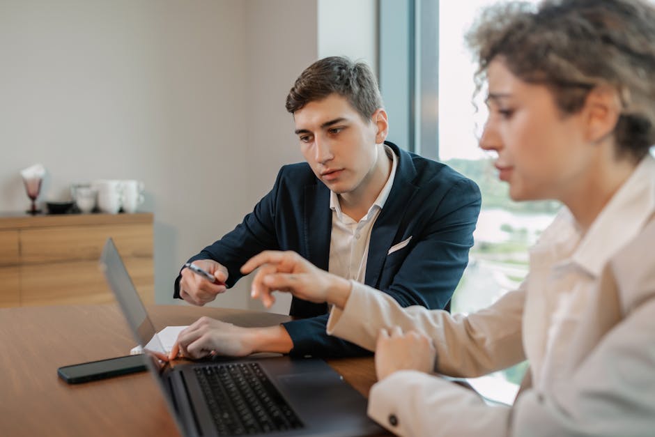 Apresentação de proposta comercial a cliente — consultor a explicar solução em laptop durante reunião 1:1